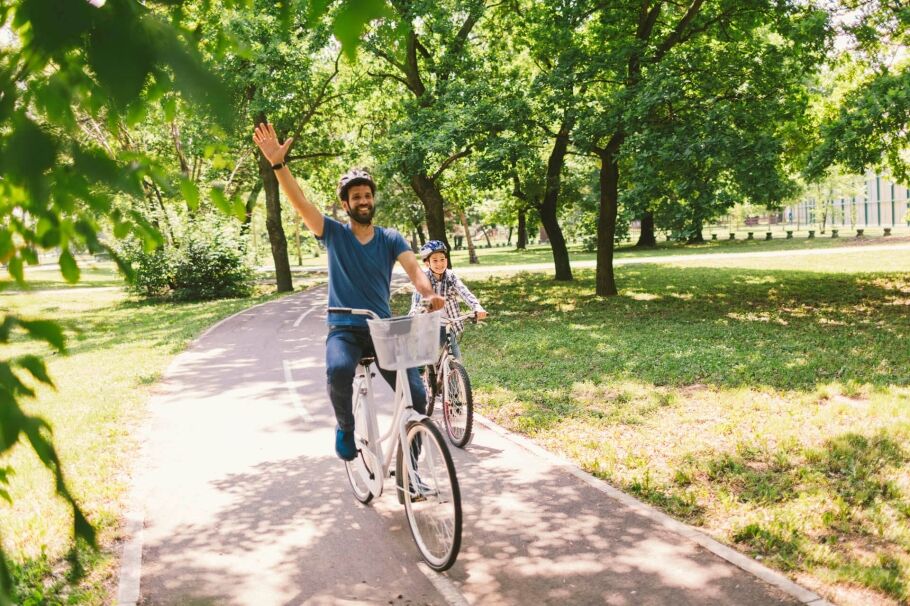 Father and son riding bicycle in the public park together - Unique Ideas for Spring Break in Orlando