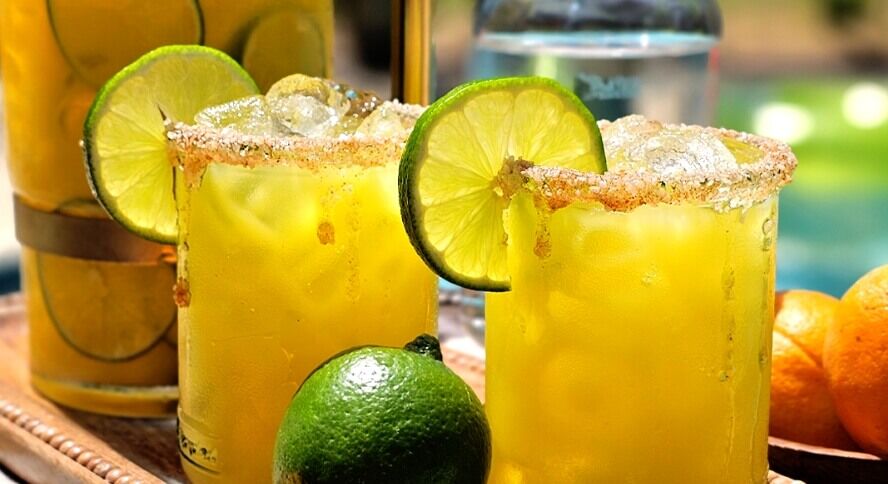 Citrus Sunshine Margarita Citrus Sunshine Margarita is shown in this colorful image including lime wedge garnishes