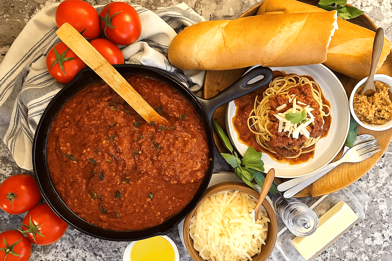 GRO-SundayGravy.4 colorful image of Sunday gravy, Italian family-style, surrounded by tomatoes, bread, and cheese