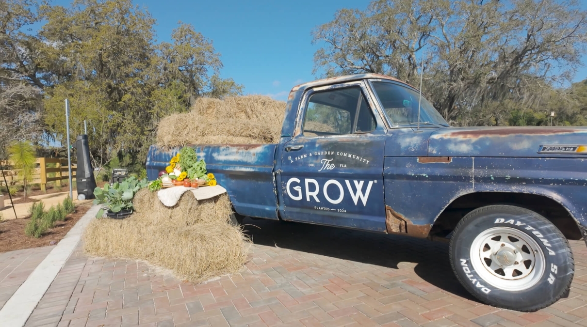 Classic blue pickup truck next to a hay bale with produce Classic blue pickup truck next to a hay bale with produce